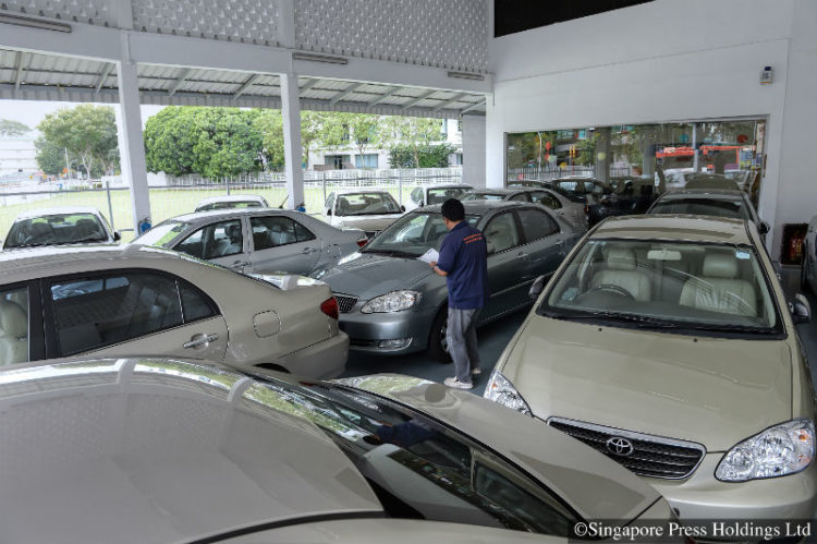 An employee from a rental car company checking the condition of a car among a fleet of cars at its premises on 4 February 2013.